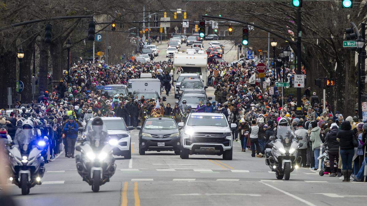 A procession of Buddhist monks is escorted by police along Hillsborough Street toward the North Carolina State Capitol in downtown Raleigh on Saturday, Jan. 24, 2026. Hundreds of well-wishers and onlookers follow the monks, who are making a 2,300-mile pilgrimage from Texas to Washington, D.C., as part of the Walk for Peace, an effort to promote peace, compassion and national unity.