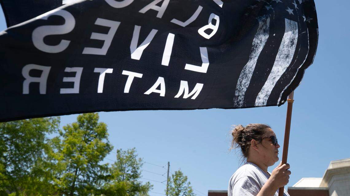 Dorothy Langston of Elizabeth City, N..C., carries her Black Lives Matter flag during a press conference at the Pasquotank Public Safety Building on Friday, May 21, 2021.