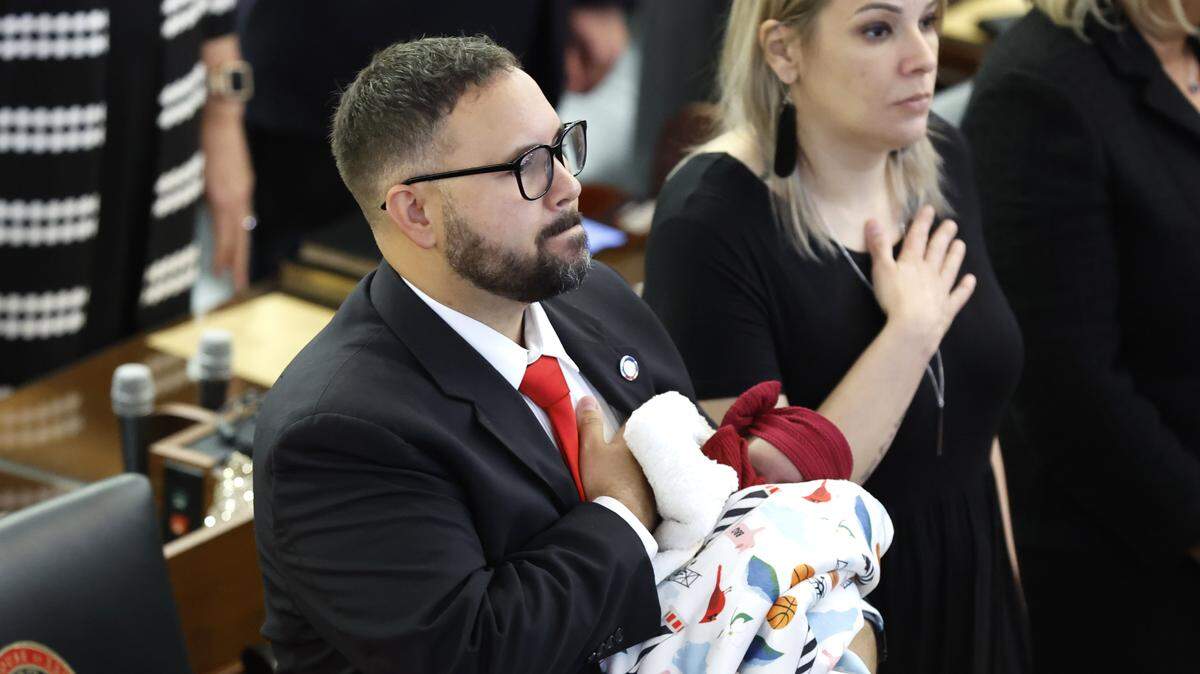 Rep. Jarrod Lowery holds his 21-day-old daughter Madysn as the Pledge of Allegiance is recited during the opening session of the N.C. House of Representatives Wednesday, Jan. 11, 2023.