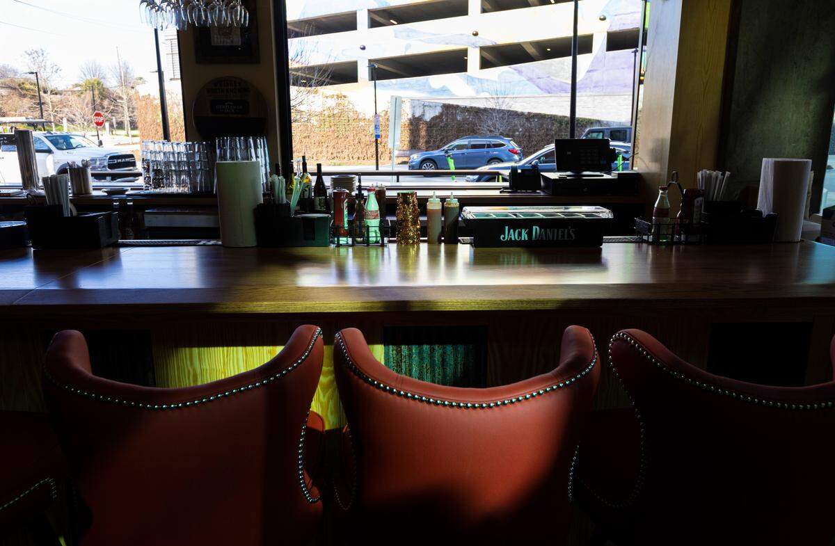 Behind the bar area, which serves everything from domestic and craft beer to signature cocktails, accordion windows open completely, giving an open-air feel that connects the outdoor patio areas to the inside dining room at Midwood Smokehouse in Raleigh, N.C. Photographed Wednesday, Feb. 8, 2023.