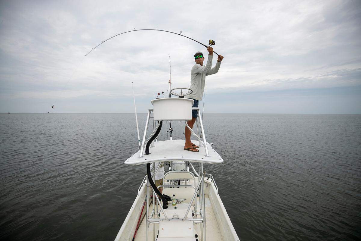 Johnny Fairbanks, a Hatteras native and a recent high school graduate casts for drum from his boat in the Pamlico Sound on Wednesday, July 21, 2021 in Hatteras, N.C. Fairbanks has started his own charter fishing business.