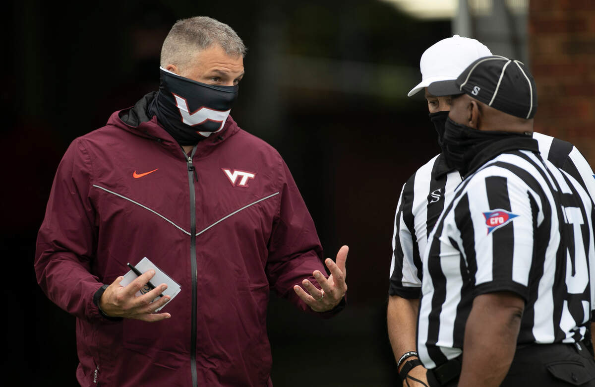 Virginia Tech head coach Justin Fuente talks with officials Gary Patterson and Terrence Ramsey prior to the Hokies’ game against North Carolina on Saturday, October 10, 2020 at Kenan Stadium in Chapel Hill, N.C.