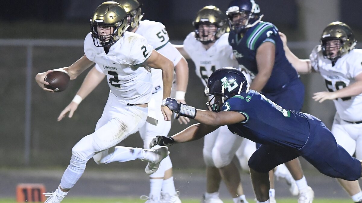 Nick Frey, left, of Cardinal Gibbons gains yards against a tackle from Dylan Reeves (3) of Leesville Road. The Cardinal Gibbons Crusaders visited the Leesville Road Pride in a high school football game on September 21, 2018. Cardinal Gibbons won 33-22.