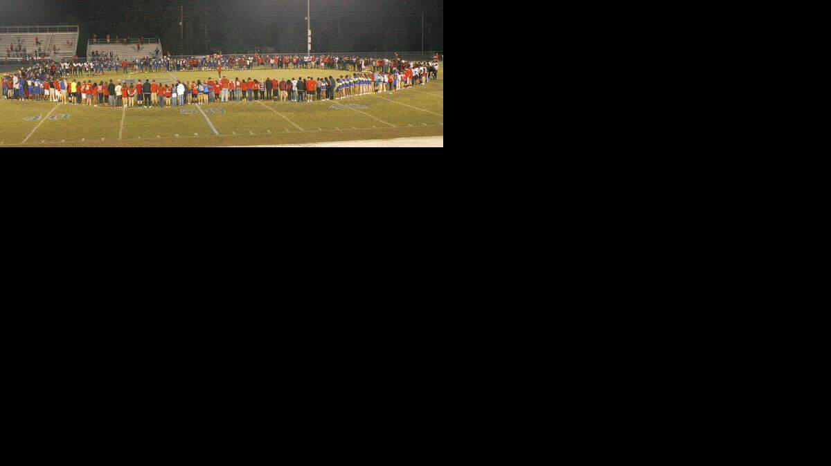 Fans and players from East Wake and Rolesville high schools form a circle after their Oct. 3, 2014, football game to honor the Rolesville Rams’ Isaiah Langston, a linebacker who collapsed before a game on Sept. 26 and later died.
