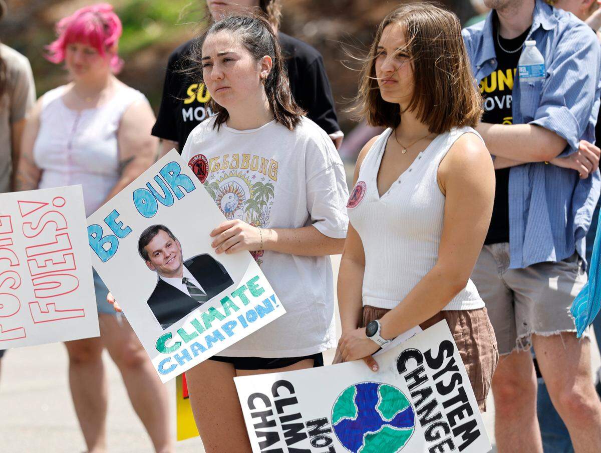 Duke students Katie Bruno, left, and Clara Brown, right, listen to a speaker during a rally and march organized by NC WARN near the N.C. Executive Mansion in Raleigh on Saturday. About 85 people gathered to pressure Gov. Josh Stein to speak out against Duke Energy and push the utility to embrace renewable energy.