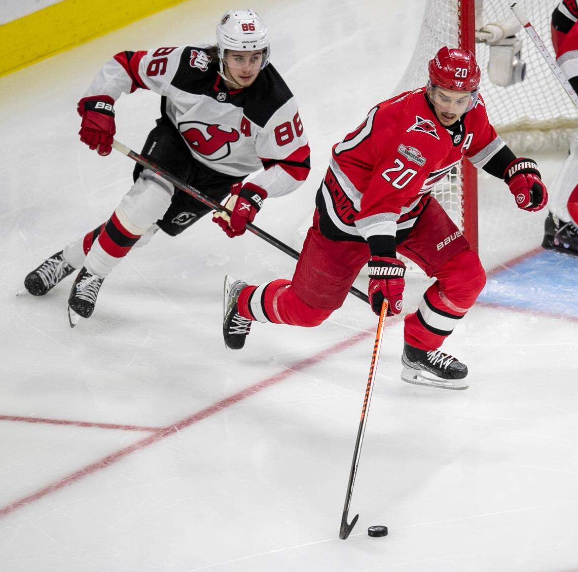 The Carolina Hurricanes Sebastian Aho (20) moves the the puck ahead of New Jersey Devils Jack Hughes (86) in the second period during Game 1 of their second round Stanley Cup playoff series on Wednesday, May 3, 2023 at PNC Arena in Raleigh, N.C.