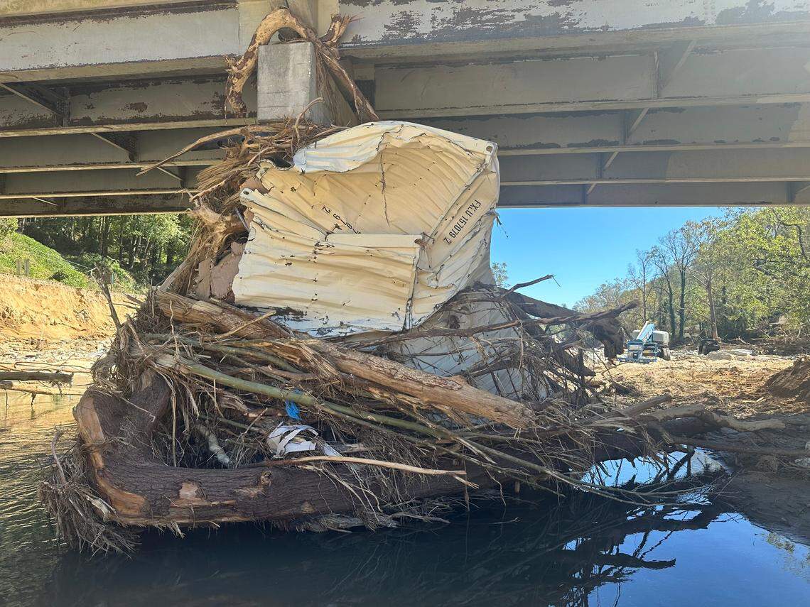 A flattened shipping container is among the debris driven against the pilings of the U.S. 64 bridge over the Rocky Broad River in Bat Cave, North Carolina.