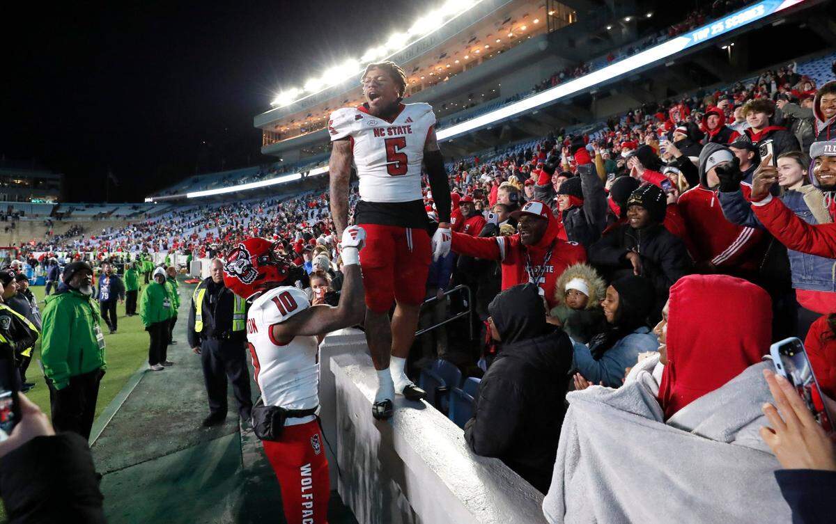 N.C. State’s DK Kaufman (5) and KC Concepcion (10) celebrate the Wolfpack’s 35-30 victory over UNC at Kenan Stadium in Chapel Hill, N.C., Saturday, Nov. 30, 2024.