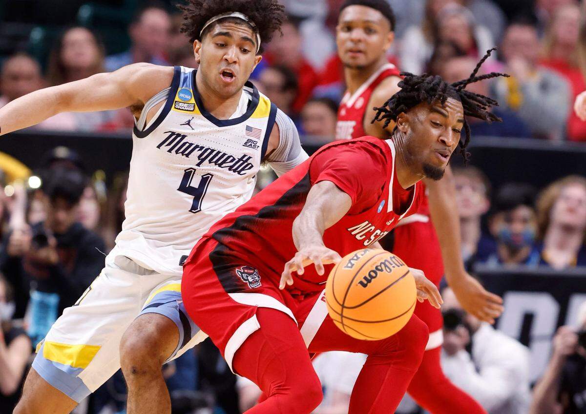 N.C. State’s Jayden Taylor (1) tries to keep control of the ball as Marquette’s Stevie Mitchell (4) defends during the first half of N.C. State’s game against Marquette in their NCAA Tournament Sweet 16 game at the American Airlines Center in Dallas, Texas, Friday, March 29, 2024.