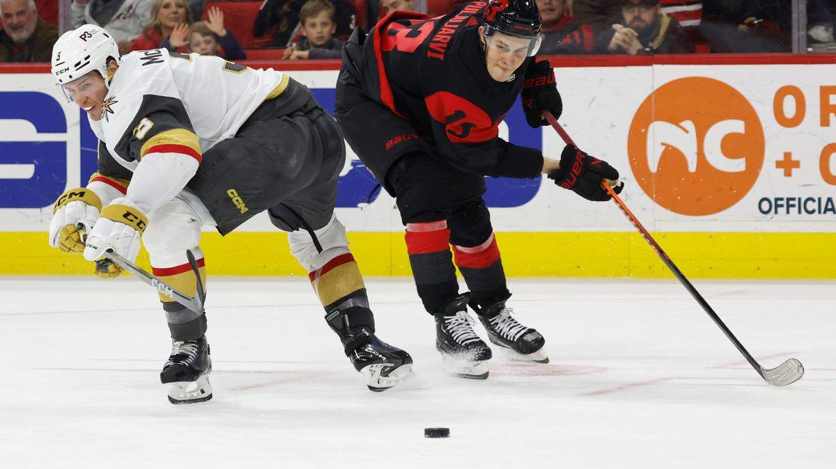 Vegas Golden Knights’ Brayden McNabb (3) and Carolina Hurricanes’ Jesse Puljujarvi (13) watch the loose puck during the second period of an NHL hockey game in Raleigh, N.C., Saturday, March 11, 2023. (AP Photo/Karl B DeBlaker)