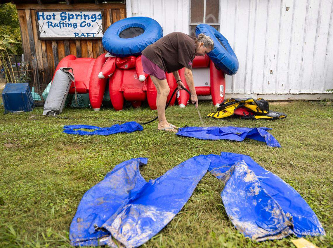 Karen McCall of Hot Springs Rafting Company cleans equipment that was damaged from Hurricane Helene flooding outside the historic home that houses the business on Friday, October 4, 2024 in Hot Springs, N.C.