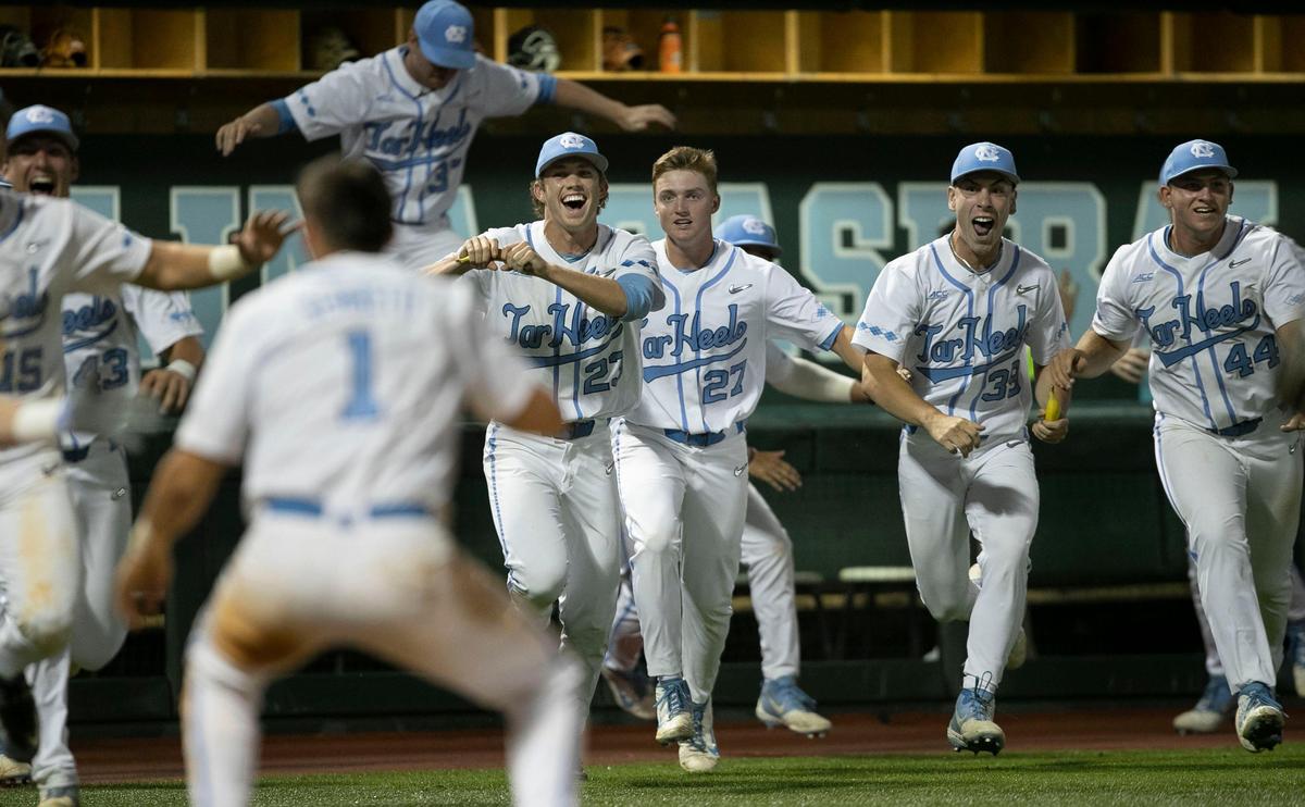 The North Carolina dugout empties as they rush the field to celebrate their 7-6 victory over UNC-Wilmington with Danny Serretti (1) after he scored the winning run in the bottom of the night inning in the NCAA Regional on Friday May 31, 2019 at Boshamer Stadium in Chapel Hill, N.C.