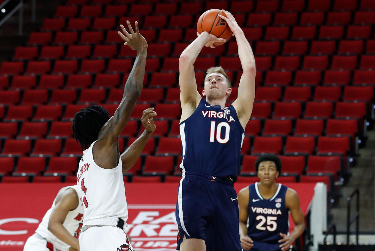 Virginia’s Sam Hauser (10) shoots as N.C. State’s Dereon Seabron (1) defends during the first half of N.C. State’s game against Virginia at PNC Arena in Raleigh, N.C., Wednesday, February 3, 2021.