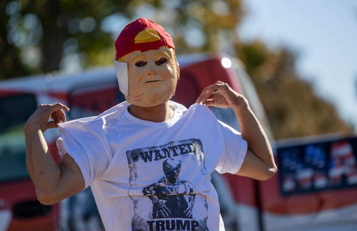A man breakdances for tips as supporters of former President Donald Trump gather outside Minges Coliseum in Greenville prior to a rally on Monday, Oct. 21, 2024. With two weeks until Election Day, Trump went on a three-city tour, in which Trump will also see the destruction caused by Hurricane Helene in Asheville and speak at a faith conference in Concord.