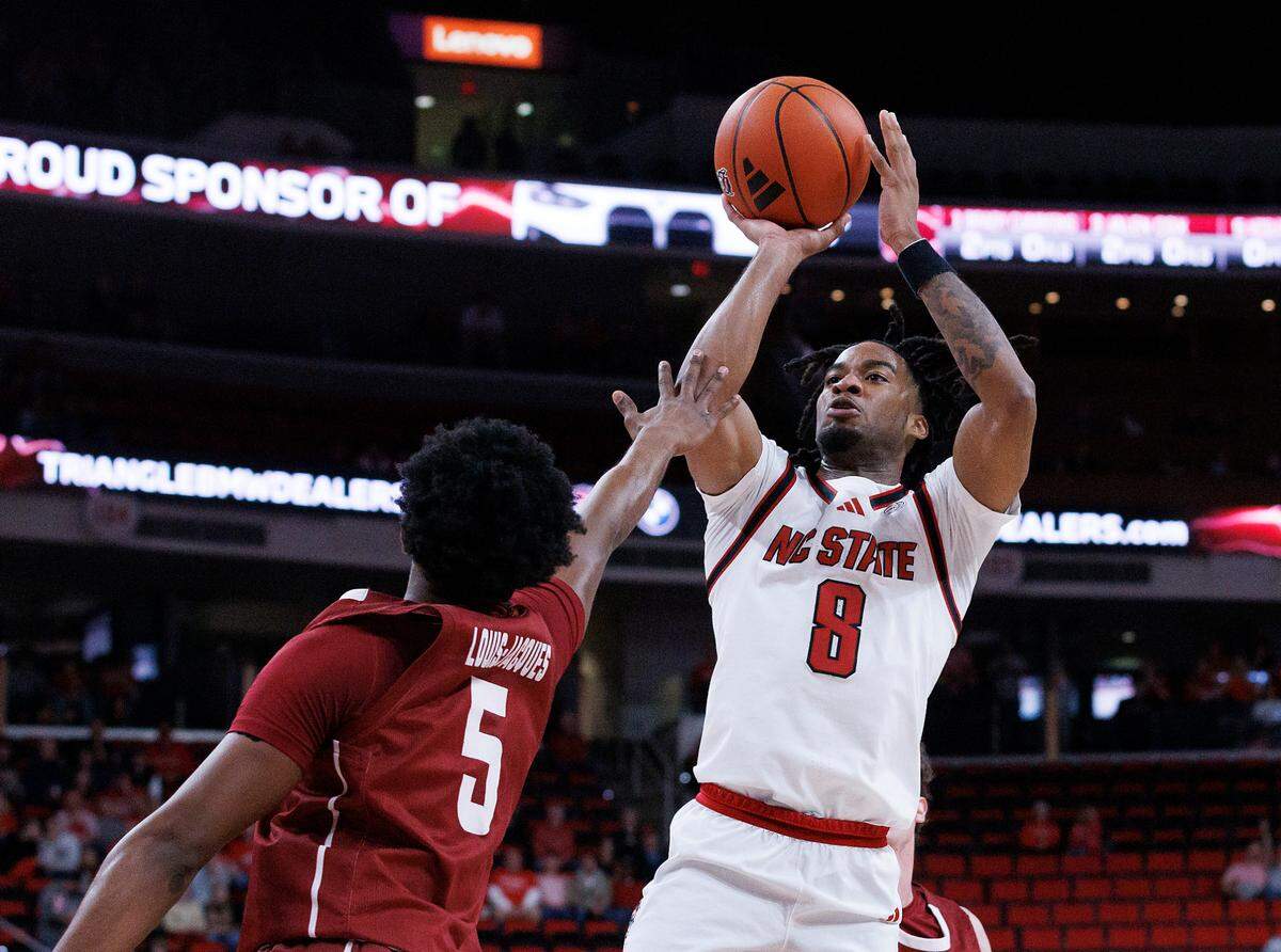 N.C. State’s Jayden Taylor shoots over Colgate’s Nicolas Louis-Jacques during the first half of the Wolfpack’s game at Lenovo Center on Monday, Nov. 18, 2024, in Raleigh, N.C.