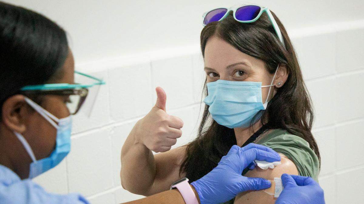 Jamie Synan, right, a Spanish teacher at Holly Ridge Middle School, gives a ‘thumbs up’ after receiving her first dose of the Moderna COVID-19 vaccine from the UNC Health mobile vaccine clinic at Praise Temple Apostolic Faith Church, on Wednesday, Feb. 24, 2021, in Clayton, N.C.