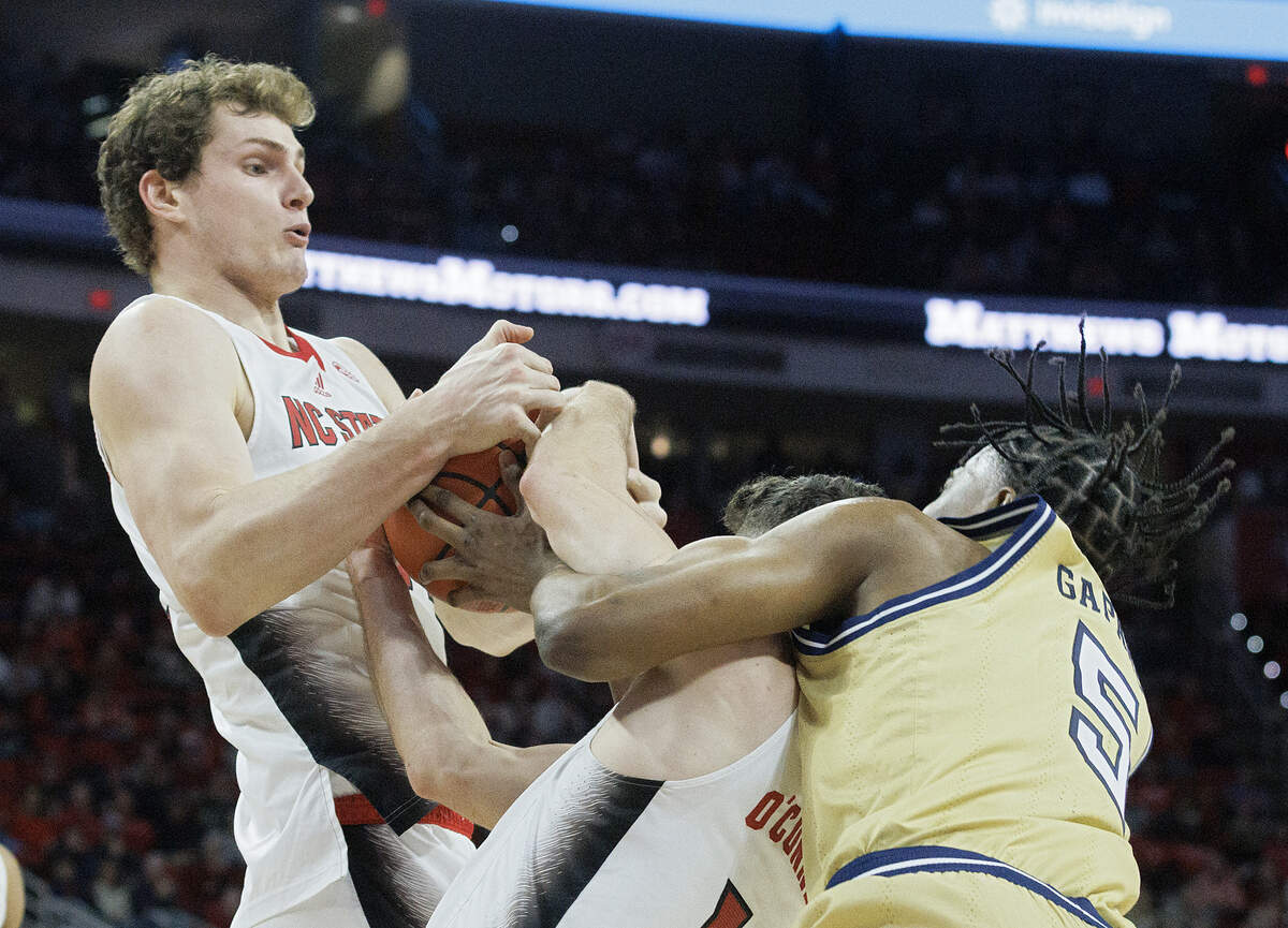 N.C. State’s Ben Middlebrooks and Michael O’Connell tangle with Georgia Tech’s Tafara Gapare for a loose ball during the second half of the Wolfpack’s 82-76 win on Saturday, Feb. 3, 2024, at PNC Arena in Raleigh, N.C.