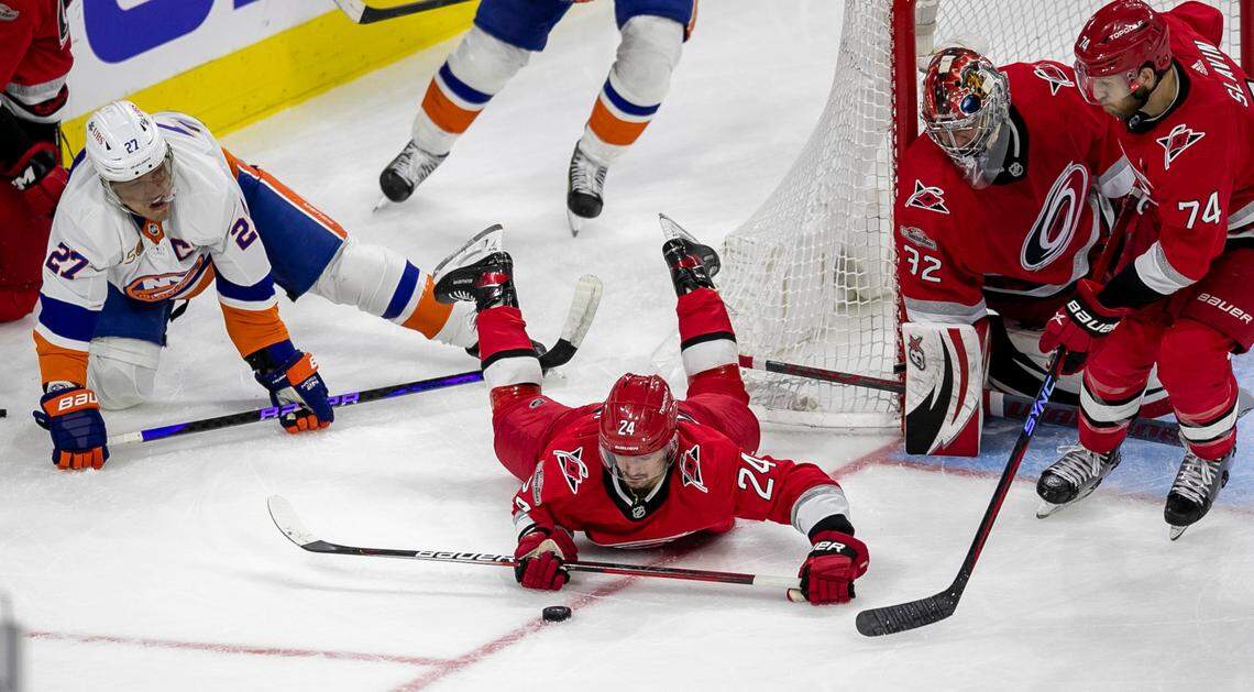 The Carolina Hurricanes Seth Jarvis (24) and Jaccob Slavin (74) work to clear the puck after a stop by goalie Antii Raanta (32) in the second period against the New York Islanders during Game 5 of their Stanley Cup series on Tuesday, April 25, 2023 at PNC Arena in Raleigh, N.C.
