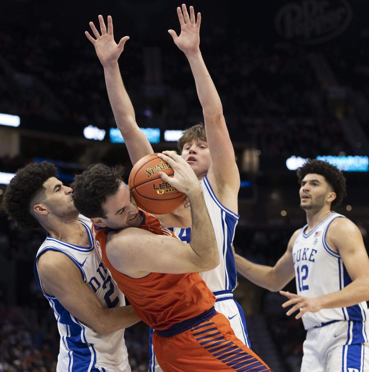 Duke guards Nikolas Khamenia and Cayden Boozer (2) trap Clemson forward Nick Davidson in the second half Friday. Clemson shot just 32.7% for the game and scored just 22 points in the first half.