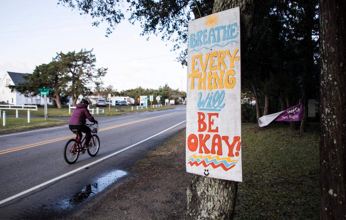 An Ocracoke, NC resident rides a bike past an encouraging sign that hangs on a tree on Irvin Garrish Highway on Sunday, Nov. 24, 2019. The Ocracoke community has experienced the many hardships brought on by flooding after a historic storm surge caused by Hurricane Dorian inundated the island on Sept. 6th.