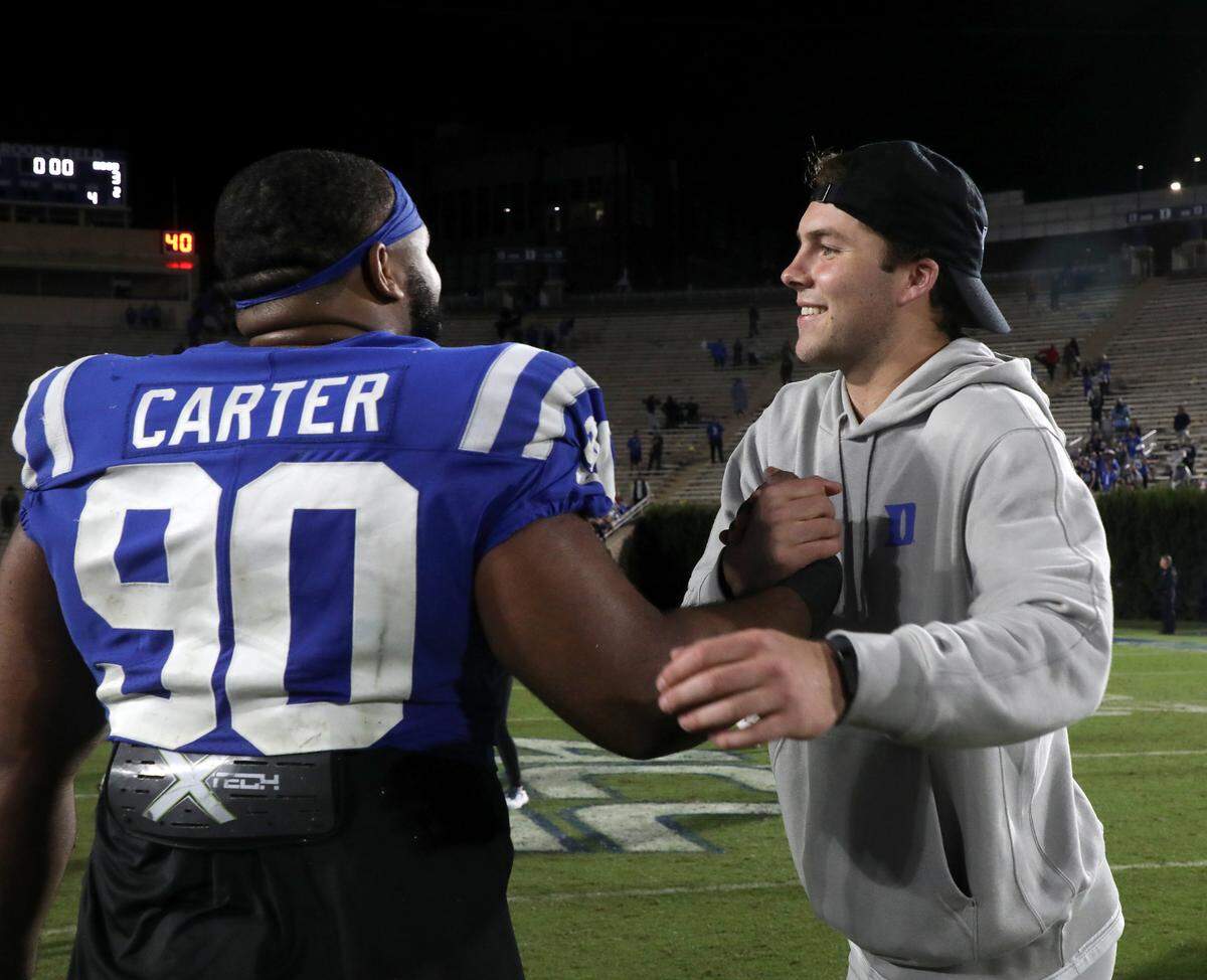 Duke’s Riley Leonard congratulates teammate DeWayne Carter following the Blue Devils’ 24-3 win over N.C. State on Saturday, Oct. 14, 2023, at Wallace Wade Stadium in Durham, N.C.