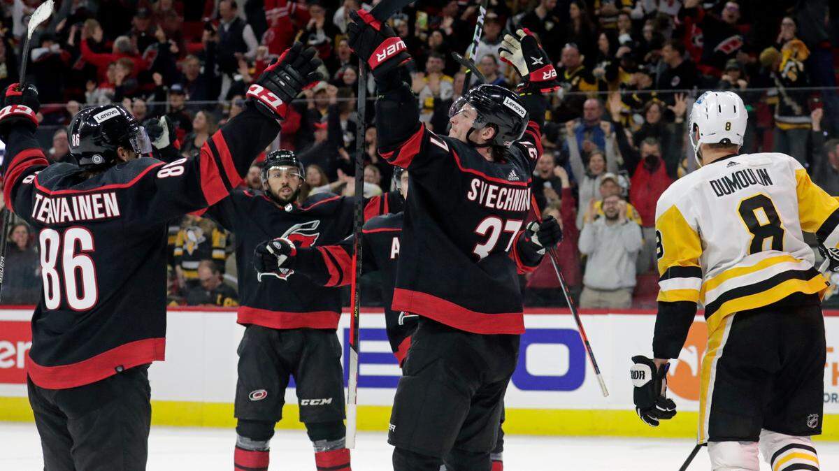 Carolina Hurricanes right wing Andrei Svechnikov (37) celebrates his game winning goal with left wing Teuvo Teravainen (86) and center Vincent Trocheck, second from left, while Pittsburgh Penguins defenseman Brian Dumoulin (8) skates away during the overtime period of an NHL hockey game Friday, March 4, 2022, in Raleigh, N.C. (AP Photo/Chris Seward)