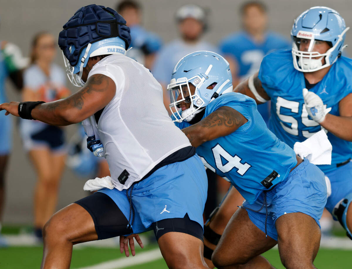 North Carolina running back British Brooks, center, runs a drill during UNC’s first football practice of the season on Friday, July 29, 2022, in Chapel Hill, N.C.