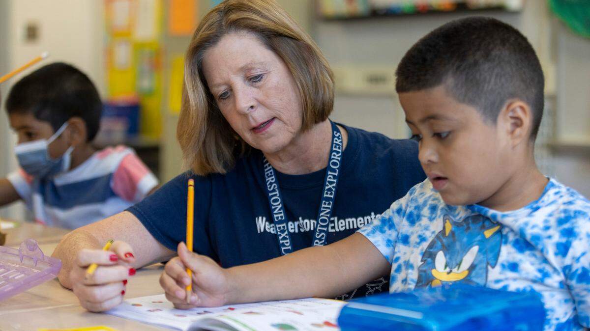 Weatherstone Elementary School first grade teacher Jennifer Ivarsson works with Brandon Flores as he does a spelling exercise on Friday, Sept. 16, 2022 in Cary, N.C. North Carolina is redesigning its K-12 language arts standards.