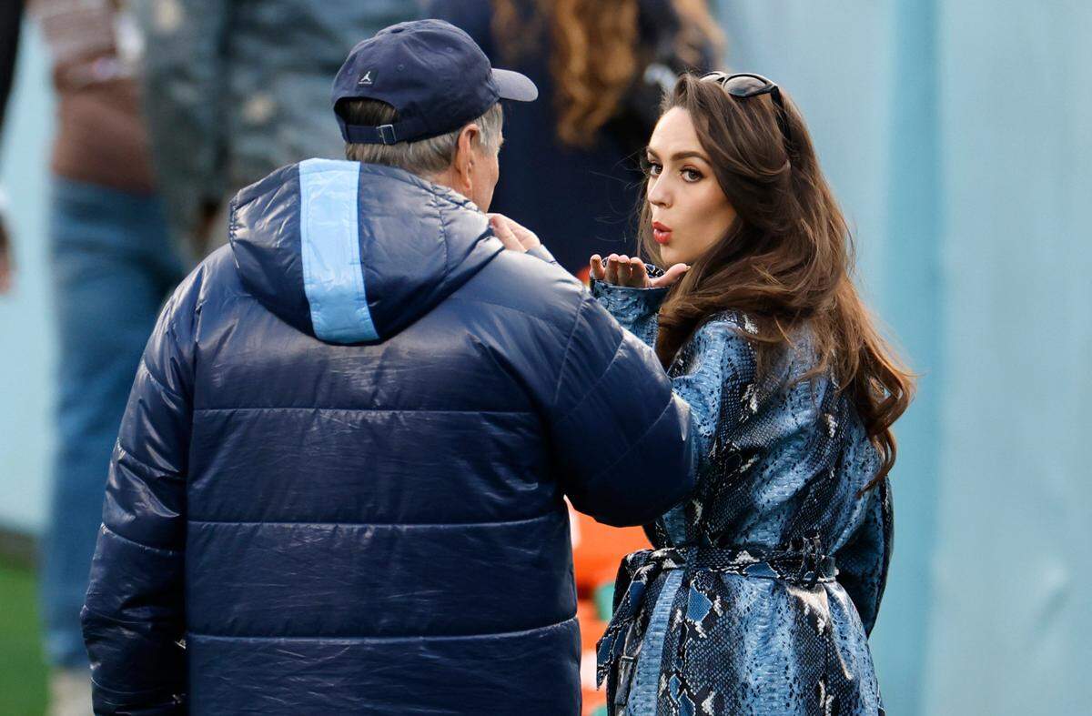 Jordon Hudson blows a kiss to North Carolina head football coach Bill Belichick at a UNC football practice. Both were in the news after she and the coach abruptly ended an interview with CBS after being asked about their relationship.
