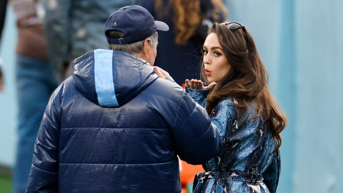 Jordon Hudson blows a kiss to North Carolina head football coach Bill Belichick at a UNC football practice. Both were in the news after she and the coach abruptly ended an interview with CBS after being asked about their relationship.