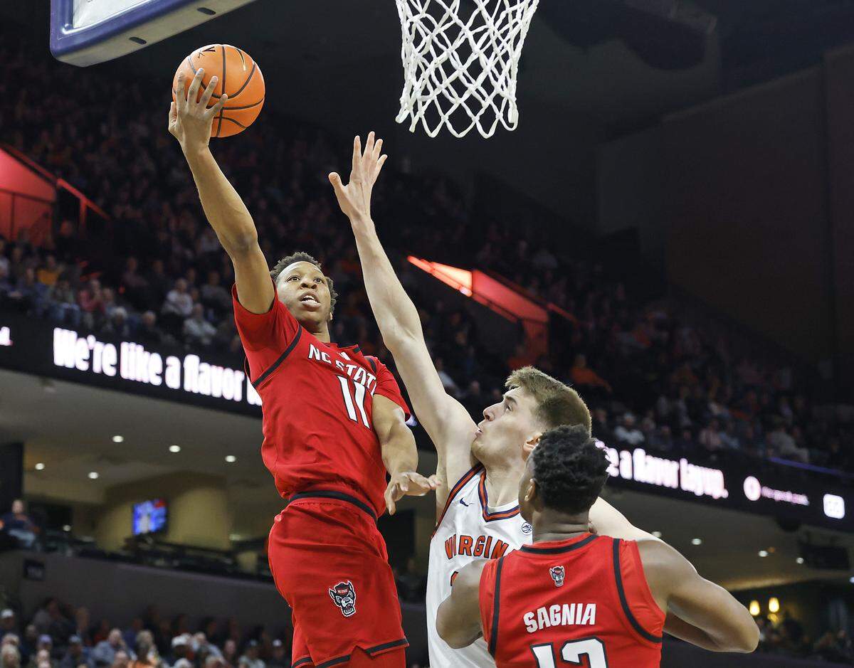 N.C. State's Quadir Copeland drives to the basket past Virginia's Johann Grünloh during the first half of the Wolfpack’s game on Thursday, Feb. 24, 2026, at John Paul Jones Arena in Charlottesville, Va. 
