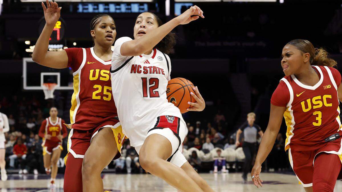 N.C. State’s Khamil Pierre drives past Southern California’s Kara Dunn and Londynn Jones during the second half of the Wolfpack’s 69-68 loss in the Ally Tipoff game on Sunday, Nov. 9, 2025, at Spectrum Center in Charlotte, N.C.