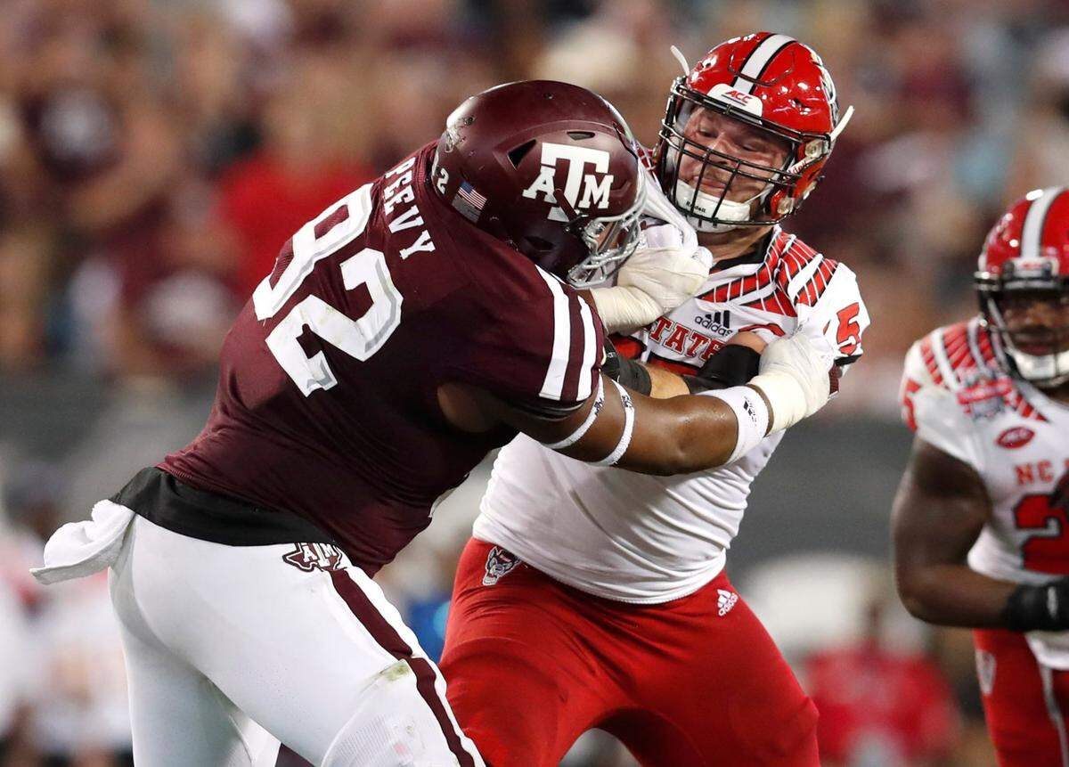 N.C. State center Garrett Bradbury (65) blocks Texas A&M defensive lineman Jayden Peevy (92) during the TaxSlayer Gator Bowl at TIAA Bank Field in Jacksonville, Fla., Monday, Dec. 31, 2018.