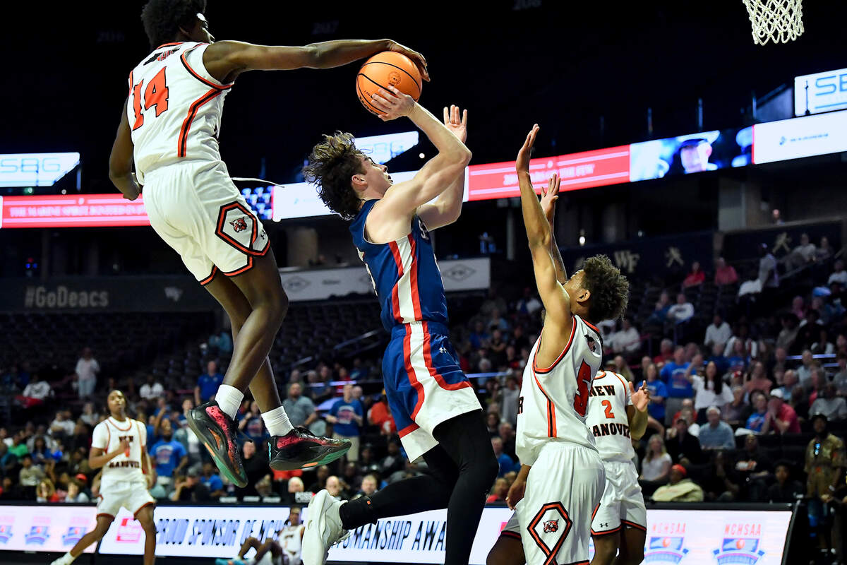 New Hanover’s Jazir Wright-McGhee (14) blocks the shot of Sanderson’s Nathan Fife (5) during the first half. The Sanderson Spartans and the New Hanover Wildcats met in the NCHSAA 4A East Regional Final in Winston-Salem, N.C. on March 12, 2025.