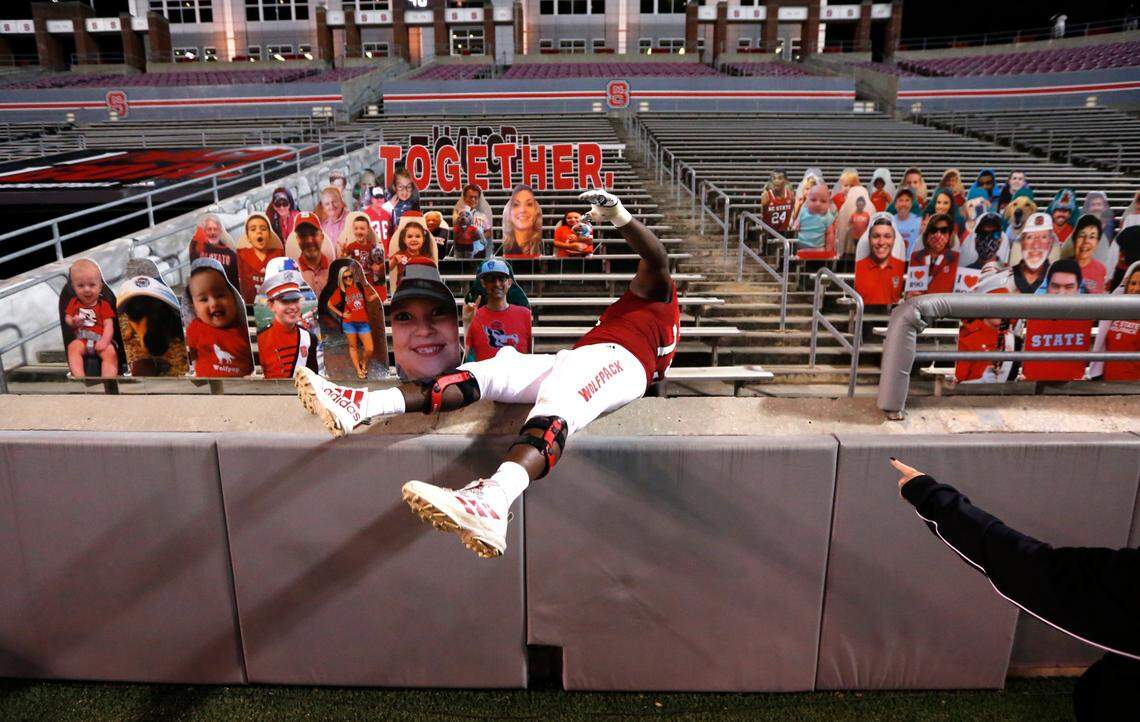 N.C. State offensive tackle Ikem Ekwonu (79) climbs into the stands to pose next to a cutout of coach Dave Doeren after N.C. State’s 45-42 victory over Wake Forest at Carter-Finley Stadium in Raleigh, N.C, Saturday, Sept. 19, 2020.