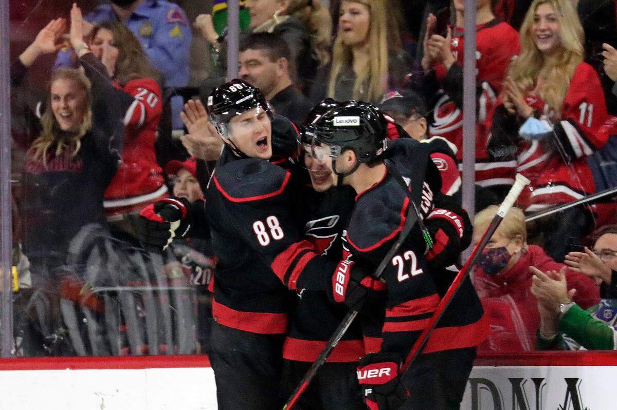 Carolina Hurricanes defenseman Brady Skjei, center, celebrates his goal against the Nashville Predators with winger Martin Necas (88) and defenseman Brett Pesce (22) during the first period of an NHL hockey game Friday, Feb. 18, 2022, in Raleigh, N.C. (AP Photo/Chris Seward)