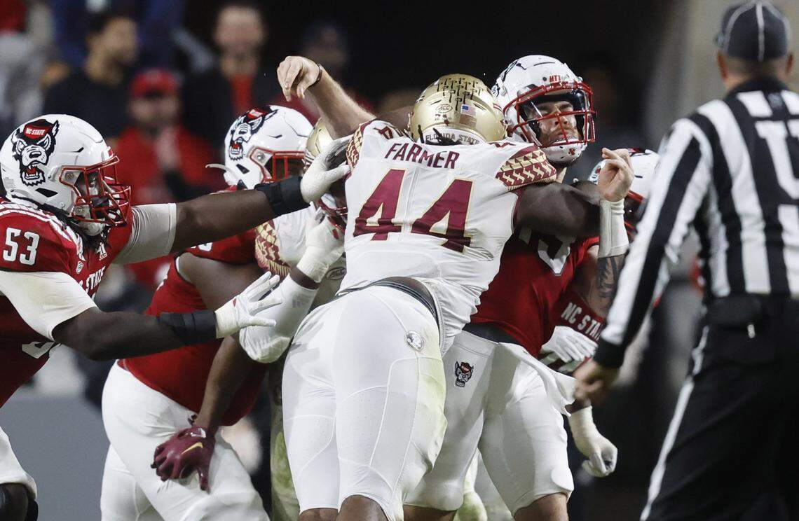 N.C. State quarterback Devin Leary (13) is hit by Florida State defensive tackle Joshua Farmer (44) as he throws during the second half of N.C. State’s game against Florida State at Carter-Finley Stadium in Raleigh, N.C., Saturday, Oct. 8, 2022. Leary was injured on the play.
