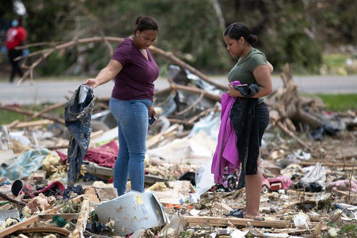 Chardae Cooper, left, helps Asia Cooper looks for her personal belongings among the debris field in a cotton field along Morning Road, after her mobile home was destroyed by a tornado spawned by Hurricane Isaias in Bertie County, N.C., on Wednesday, August 5, 2020.