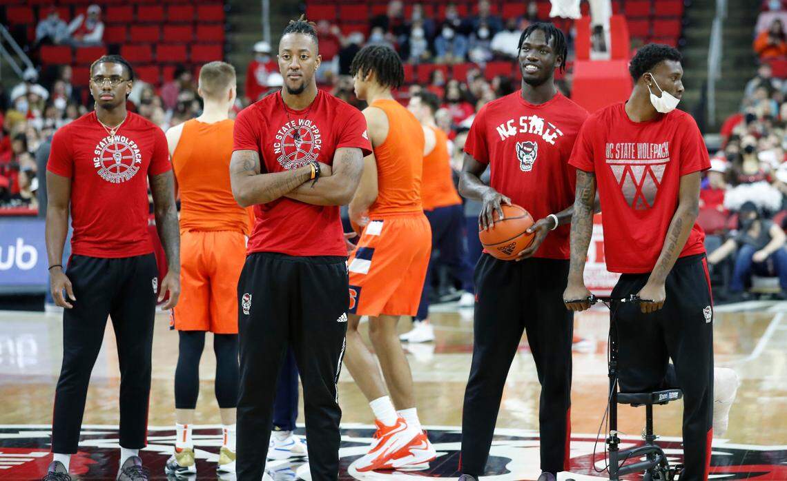 From left, N.C. State’s Greg Gantt, Manny Bates, Ebenezer Dowuona and Ernest Ross watch warmups before N.C. State’s game against Syracuse at PNC Arena in Raleigh, N.C., Wednesday, Feb. 2, 2022.