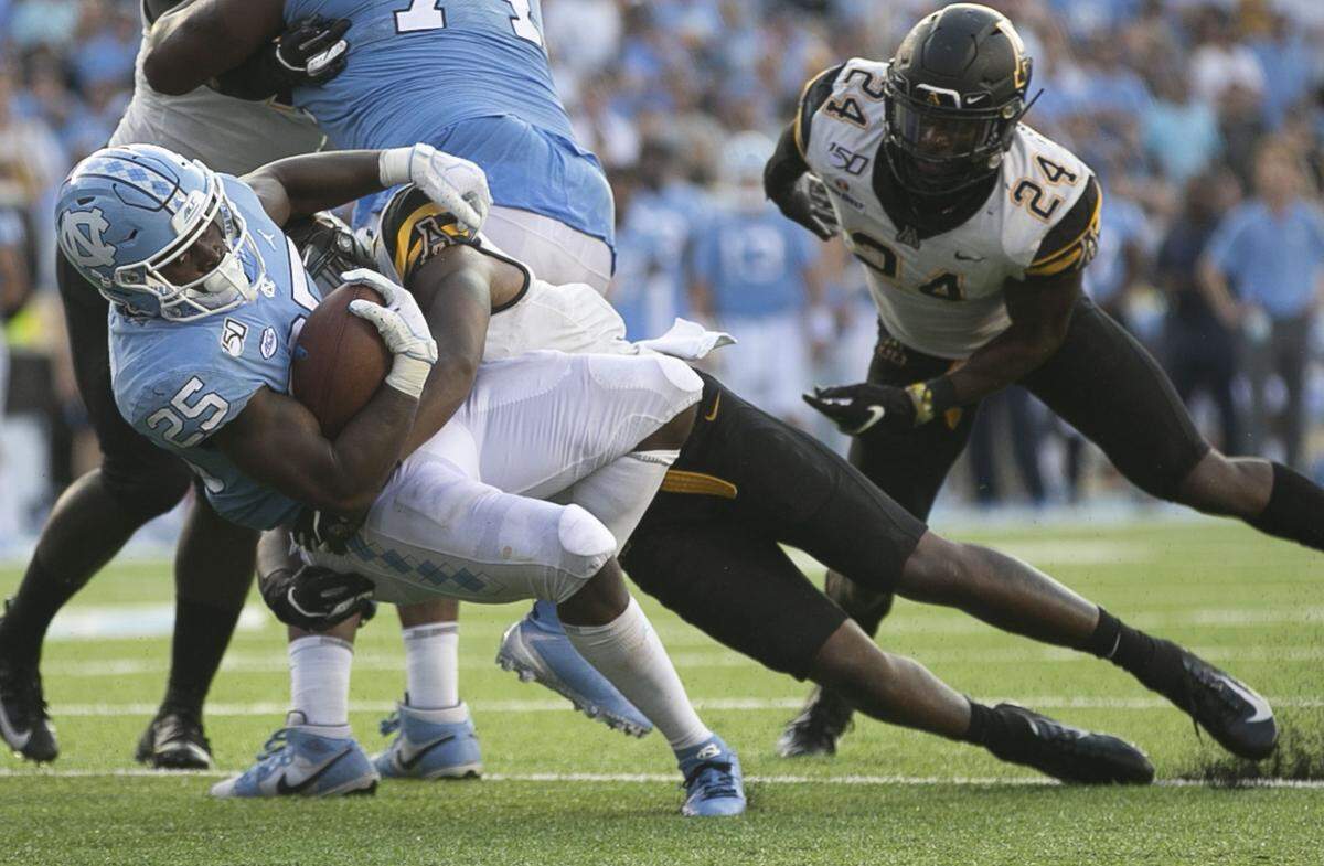 North Carolina’s Javonte Williams (25) is stopped by Appalachian State’s after a three-yard gain in the fourth quarter on Saturday, September 21, 2019 at Kenan Stadium in Chapel Hill, N.C.