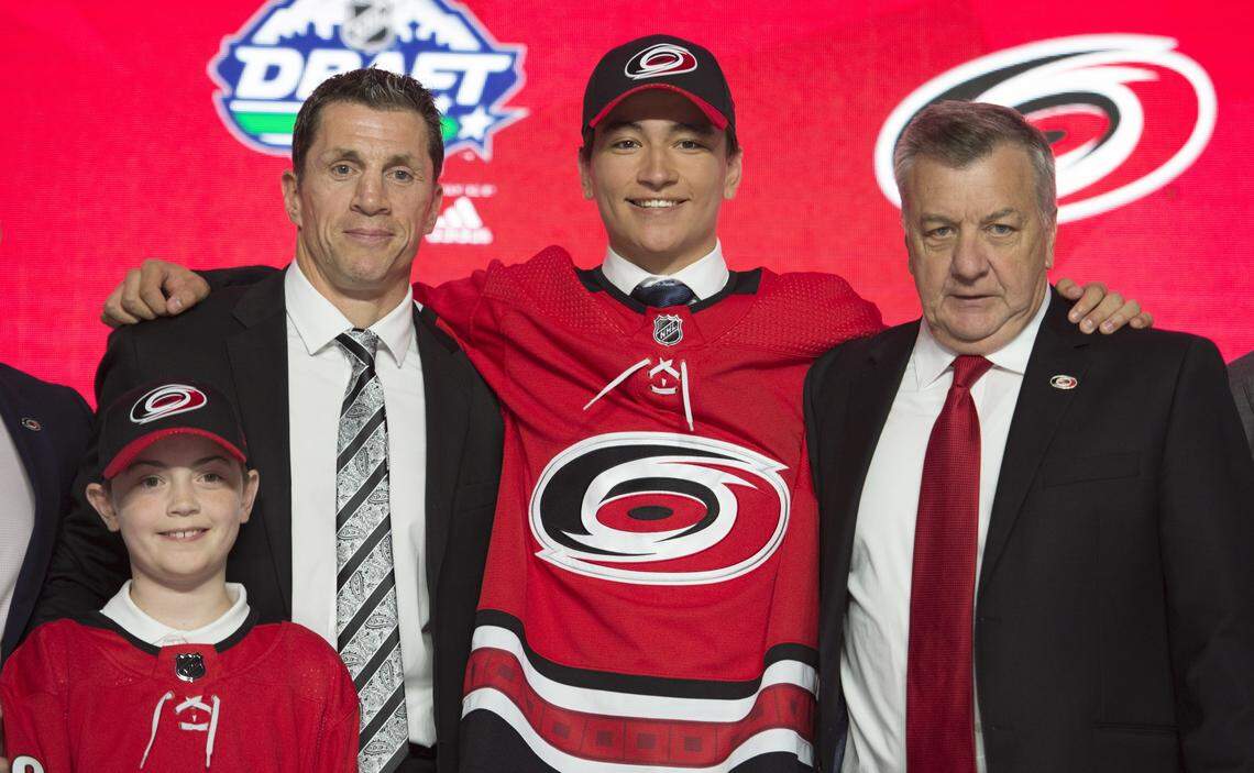 Ryan Suzuki smiles while wearing a Carolina Hurricanes jersey during the first round of the NHL hockey draft Friday, June 21, 2019, in Vancouver, British Columbia.
