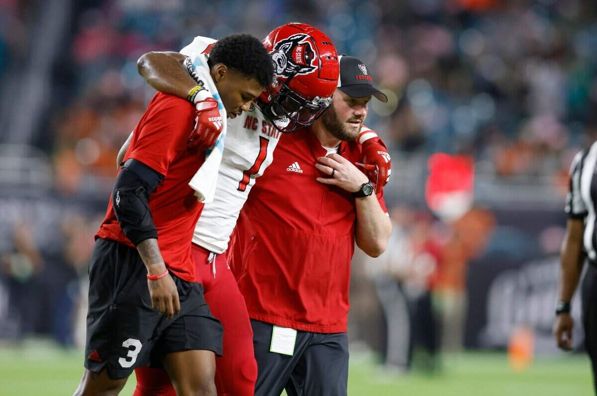N.C. State linebacker Isaiah Moore (1) is helped off the field during the first half of N.C. States game against Miami at Hard Rock Stadium in Miami Gardens, Fla. Saturday, Oct. 23, 2021.
