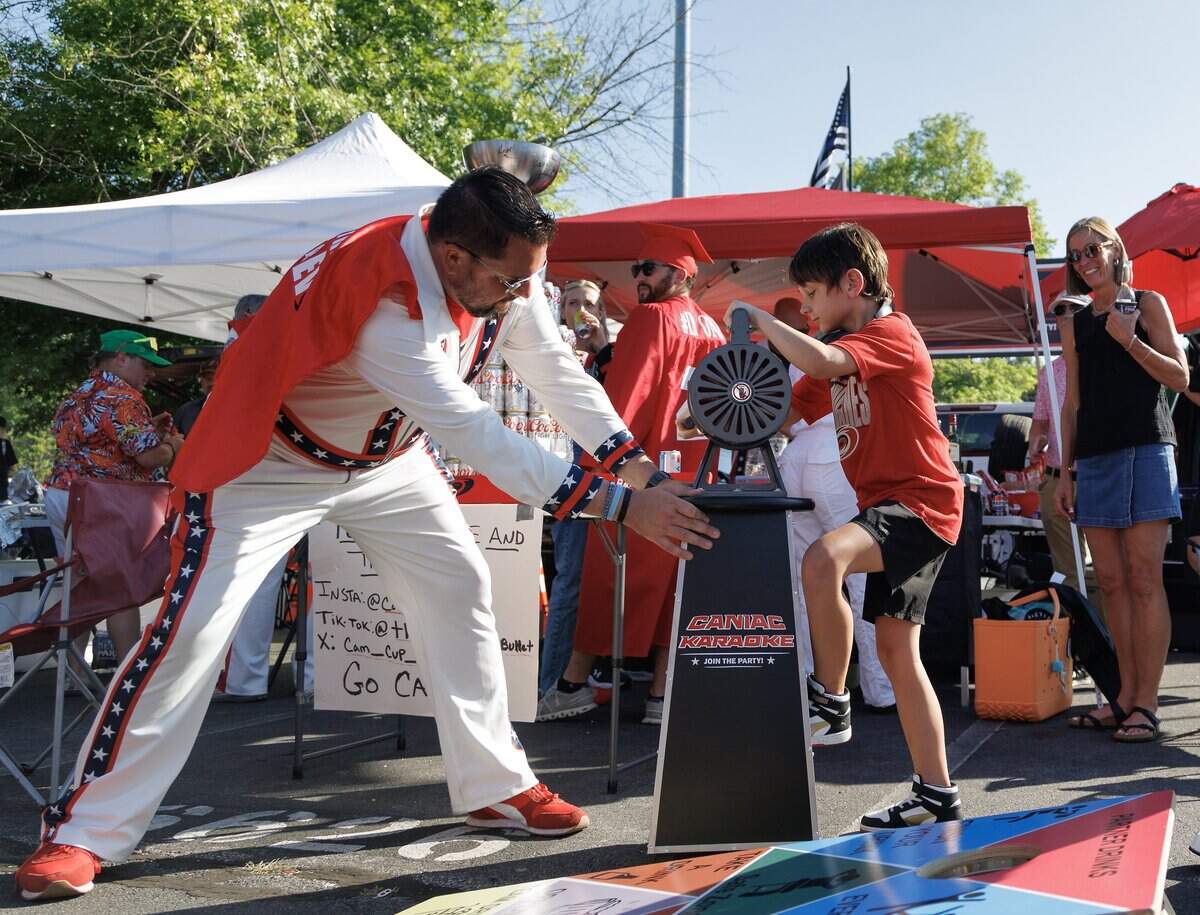 Adam Averkamp helps Colten Langdale, 9, sound a siren during a tailgate outside Lenovo Center in Raleigh, N.C. prior to the Carolina Hurricanes’ second game matchup against the Vegas Golden Knights in the Stanley Cup Final on Thursday, June 4, 2026.