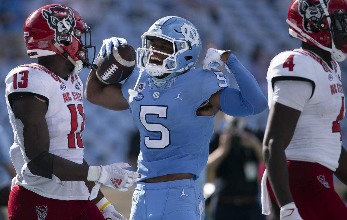 North Carolina’s Dazz Newsome (5) celebrates in front of N.C. State’s Tyler Baker-Williams (13) after a nine-yard gain in the third quarter at Kenan Stadium on Saturday, October 24, 2020 in Chapel Hill, N.C.