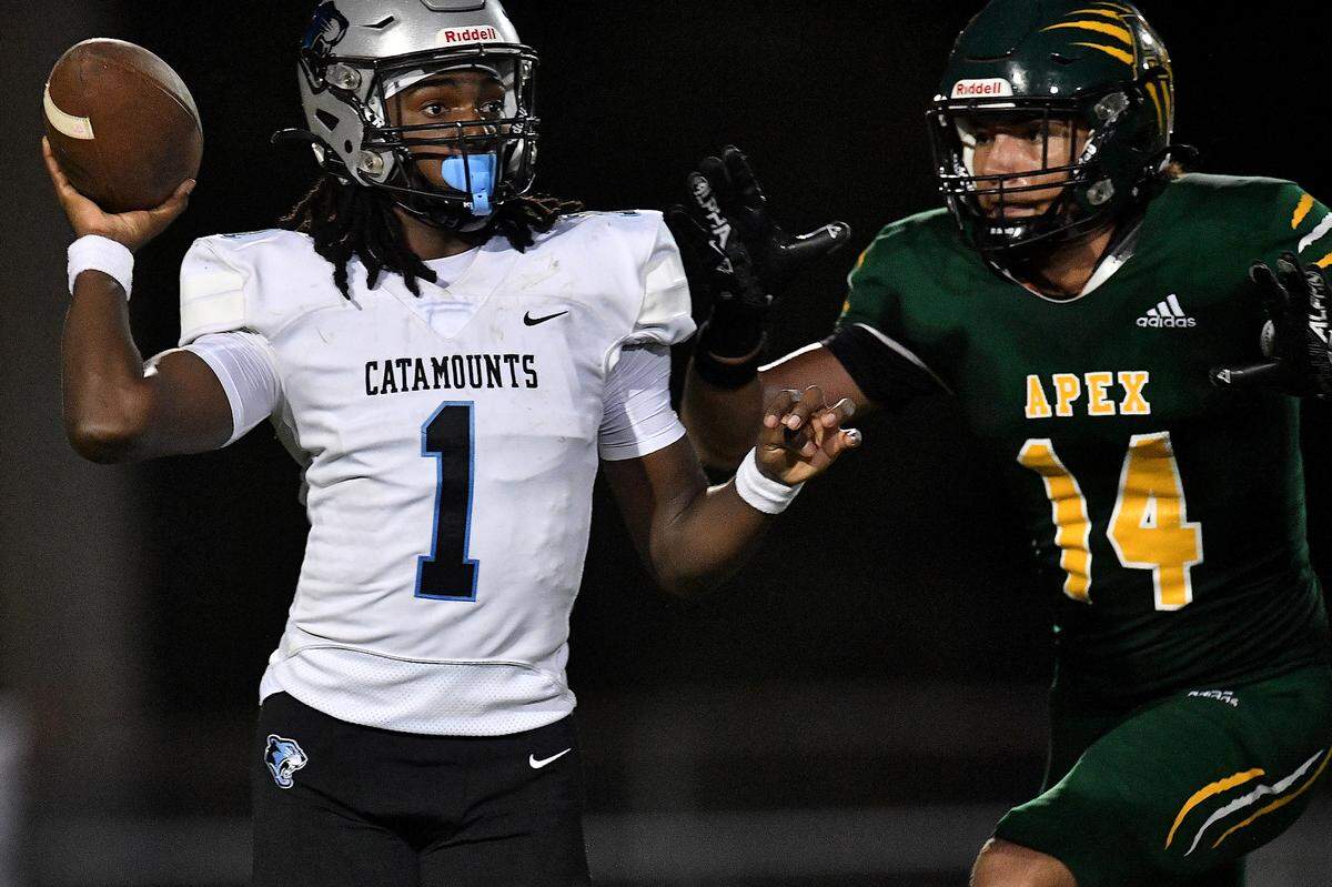 Panther Creek quarterback Tyler Walker (1) looks to pass under pressure from Apex’s Britton Thomas (14) during the first half. The Apex Cougars and the Panther Creek Catamounts met in a conference football game in Apex, N.C. on September 20, 2024.