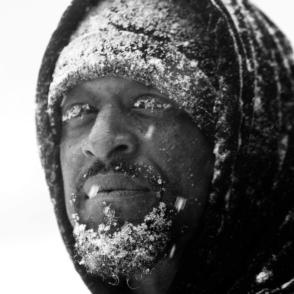 Snow clings to Turron Williams’ beard and eyelashes Wednesday, February 11, 2014 on Hammond Road as snow pounds the Triangle. Williams was helping push cars stuck in the snow.