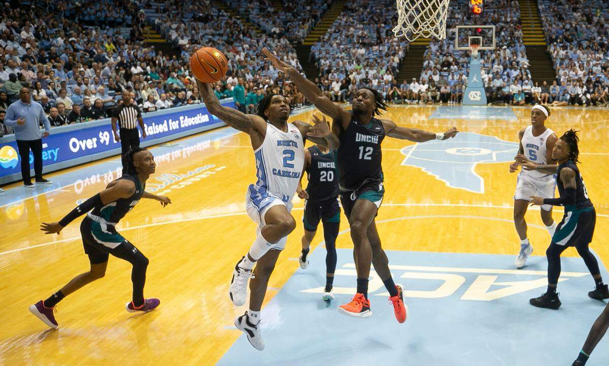 North Carolina’s Caleb Love (2) drives to the basket against UNC Wilmington’s Victor Enoh (12) in the second half on Monday, November 7, 2022 at the Smith Center in Chapel Hill, N.C. Love scored 17 points in the Tar Heels’ victory.