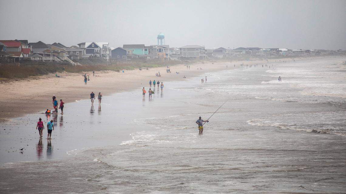 Beachgoers dot Oak Island’s beach Monday, Aug. 3, 2020 as Tropical Storm Isaias moves towards the southeast coast. The storm is expected to strengthen to a hurricane before making landfall.