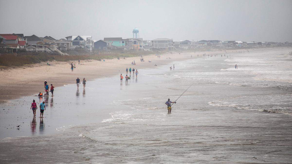 Beachgoers dot Oak Island’s beach Monday, Aug. 3, 2020 as Tropical Storm Isaias moves towards the southeast coast. The storm is expected to strengthen to a hurricane before making landfall.