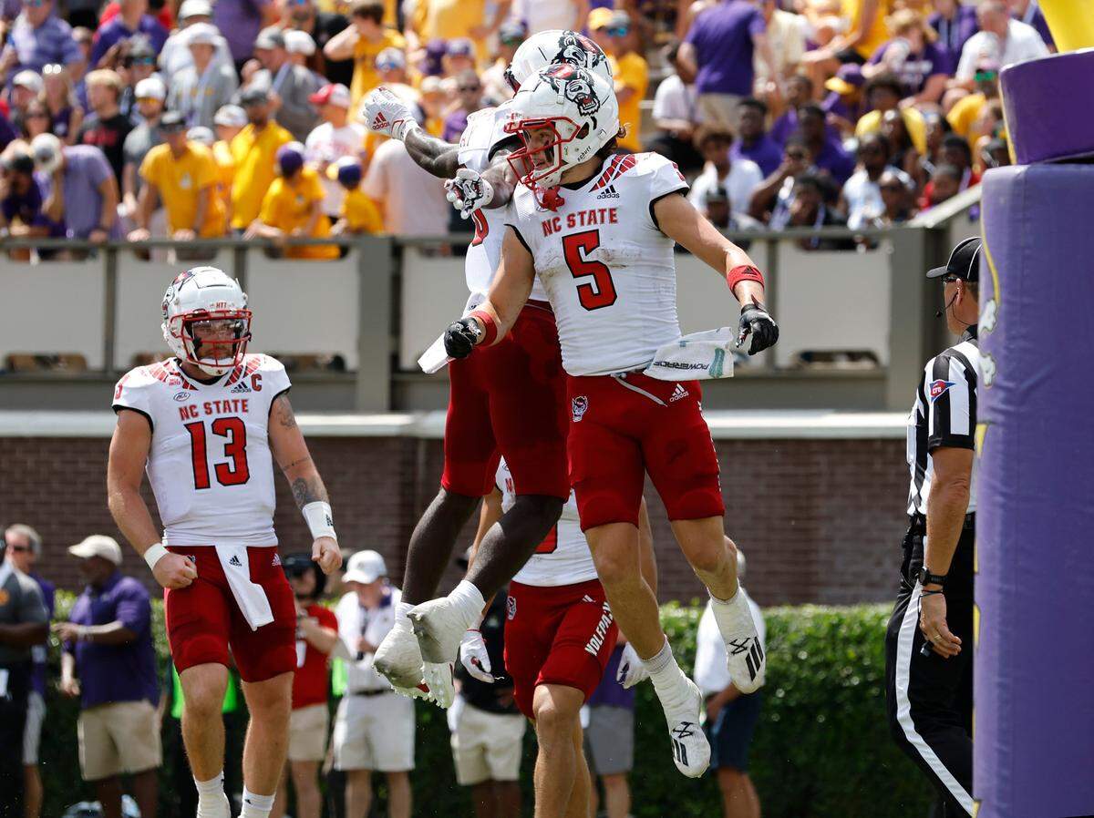 N.C. State wide receiver Thayer Thomas (5) celebrates with wide receiver Julian Gray (8) after scoring on a 12-yard touchdown reception during the first half of N.C. State’s game against ECU at Dowdy-Ficklen Stadium in Greenville, N.C., Saturday, Sept. 3, 2022.